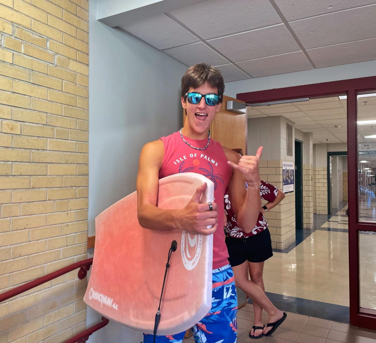 Senior Joe Keroack catching the spirit on Surfer vs. Biker day, board in hand and ready to ride the wave!